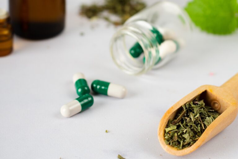 Close up medical capsules with herbs table