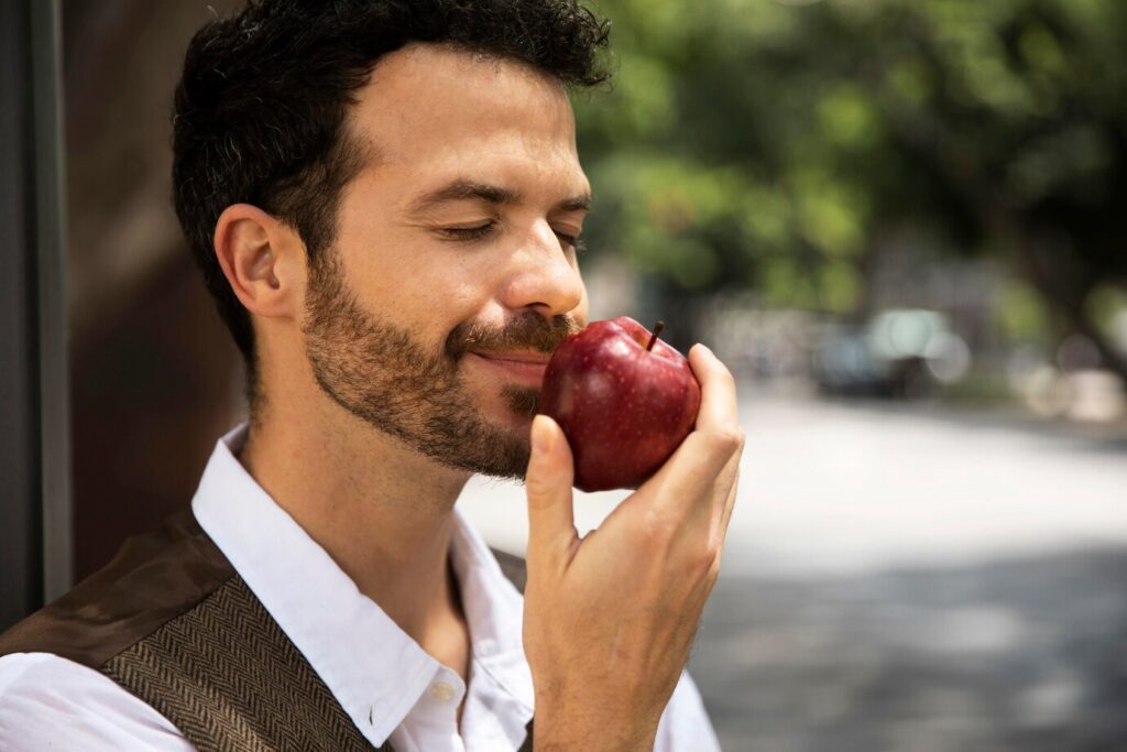 Man smelling an apple, source of farnesene terpene.