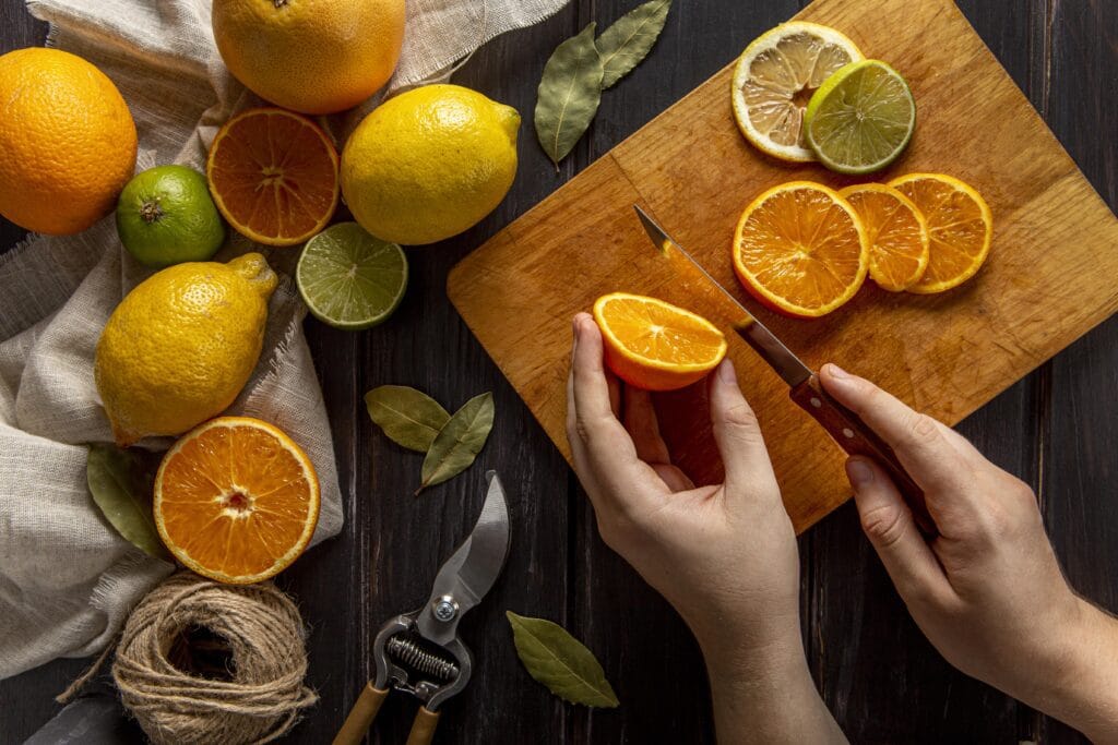 Person cutting citrus fruit on wooded cutting board demonstrating scent of Nerolidol Terpene.